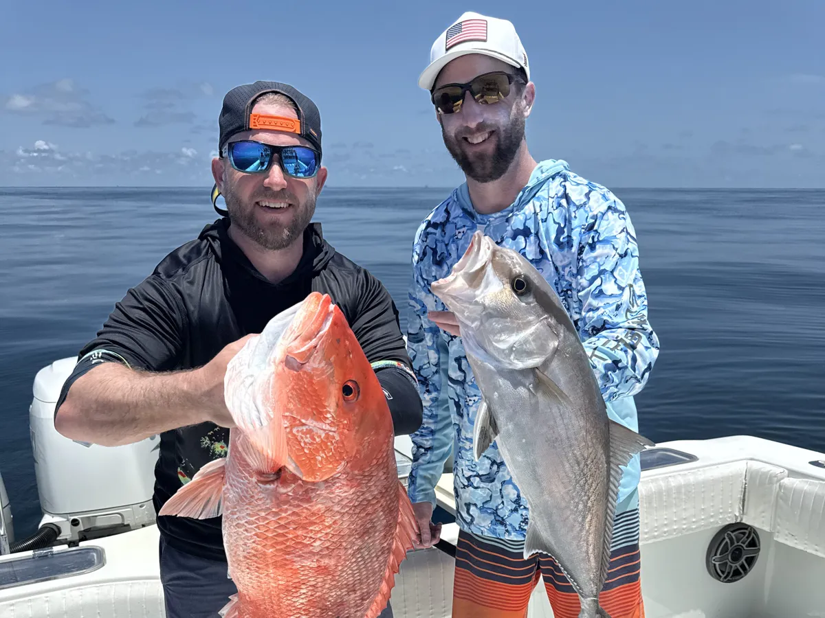 Bryan and his brother holding their catch on the boat