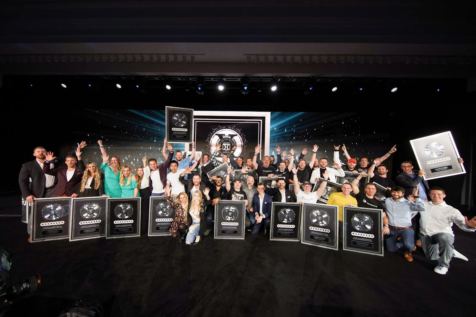 The Two Comma Club X winners celebrating on stage with their awards
